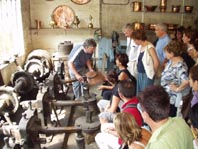 Démonstration dans l'atelier des marteaux actionnés par le moulin.